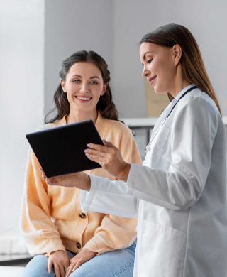 Stock photo of a female physician and a patient looking at a tablet, used to explain finding a mammogram imaging provider